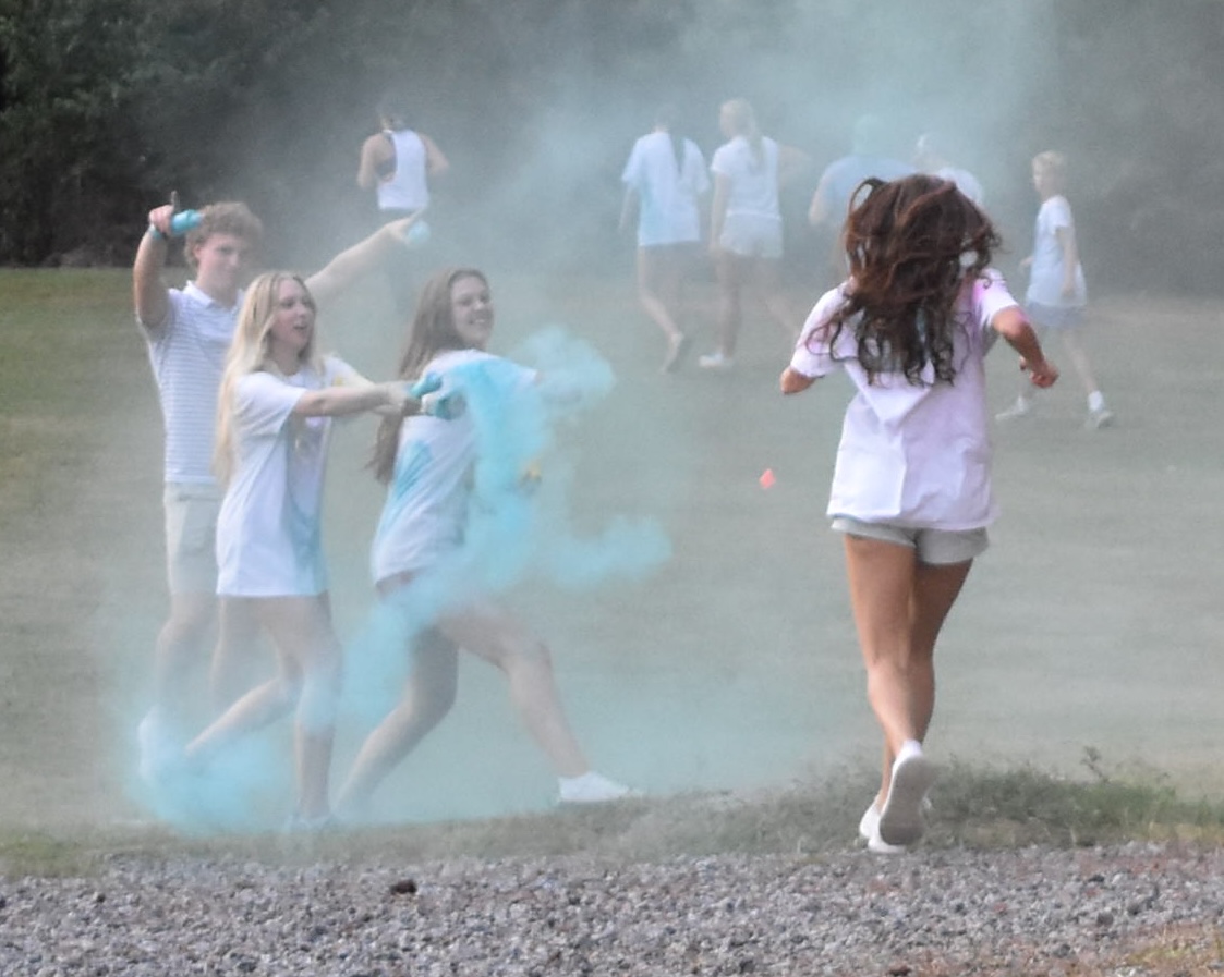 Emily Shonerd and Phoebe Rowe, presidents of the LLL club, throw color
powder at runners during the memorial run to honor Liv Teverino.