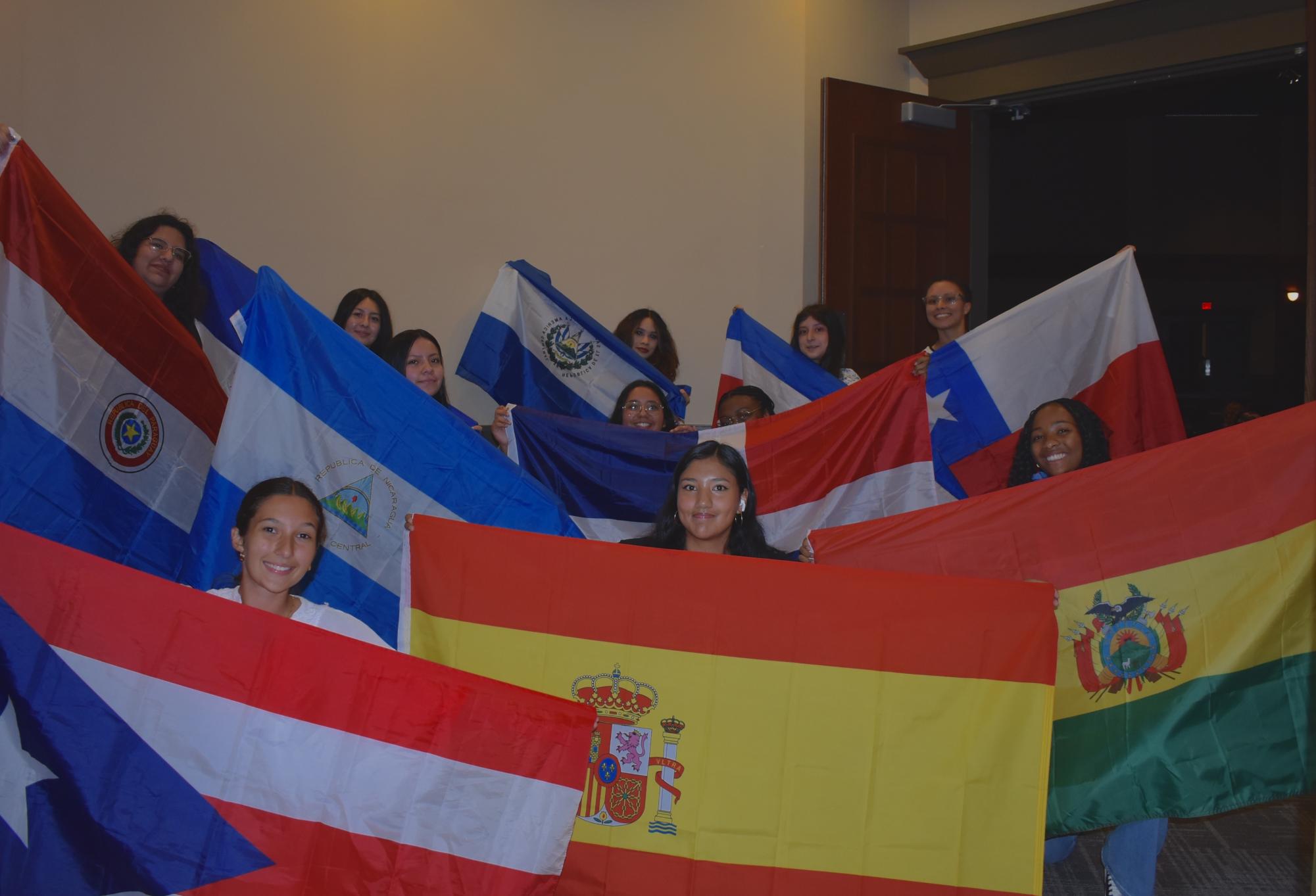 MHS students hold up flags representing every Hispanic country and Brazil.