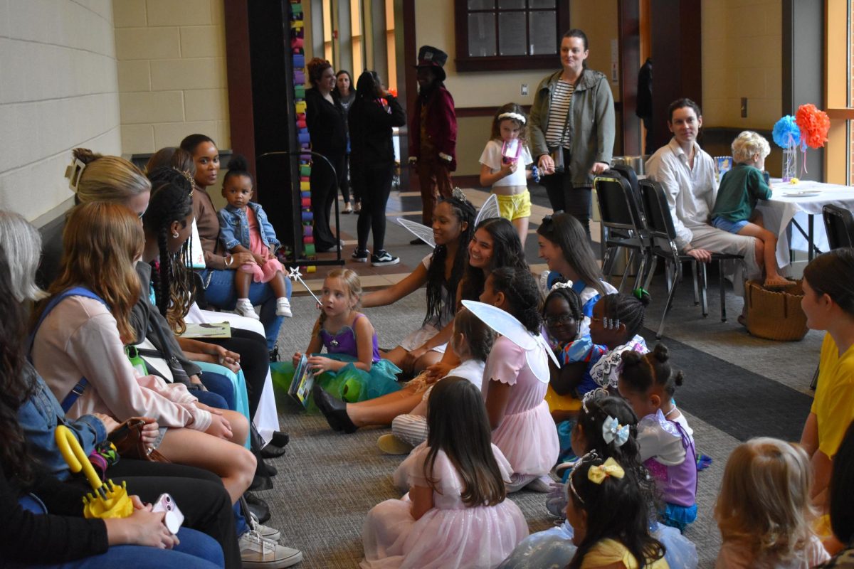 Cast members and kids alike listen to a story time, a unifying moment of the event.
