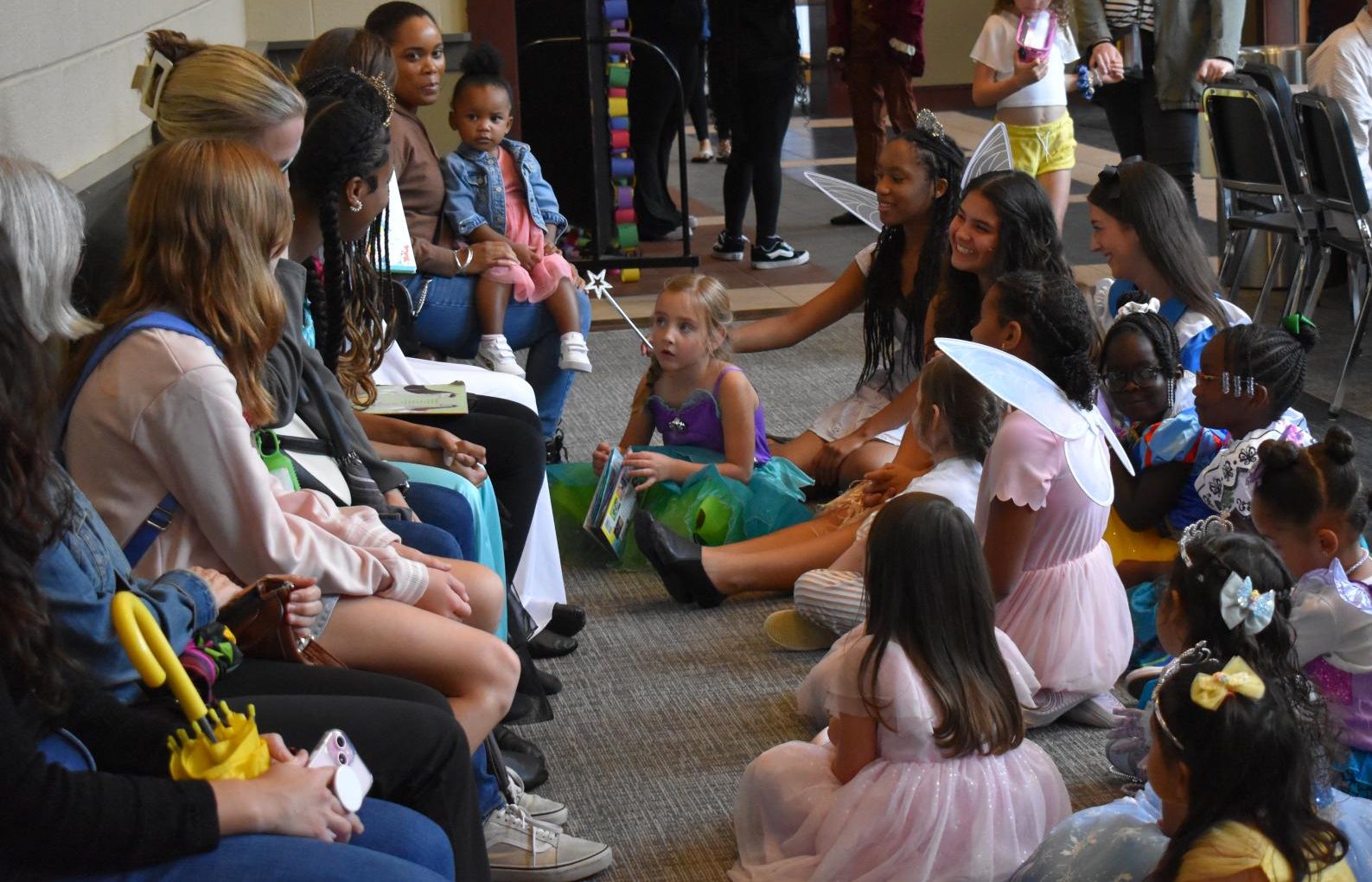 Cast members and kids alike listen to a story time, a unifying moment of the event.
