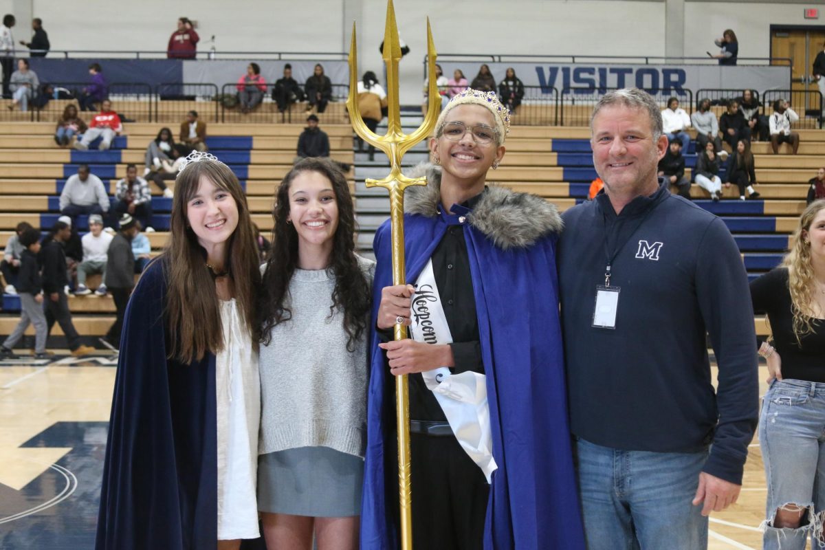 Hoopcoming King Jayden Coleman (12) with celebratory crown, cape, and trident. 