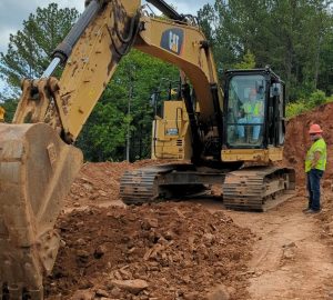 Coach Joe Street practices excavator skills on a field trip at a C. W. Matthews
project. All of the students got to give it a try as well.