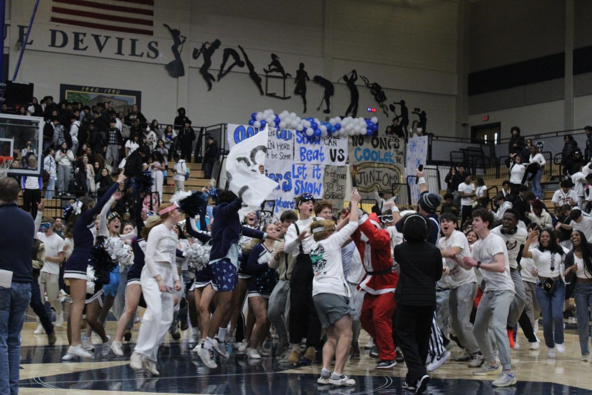 Juniors Cole Baumgartner and Harry Corr hold the spirit stick as the class gathers to celebrate their first pep rally victory.