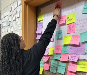 E'monie Blakeney (10) places her Women's History Month sticky note on the wall to show her appreciation for the important women in her life. 
