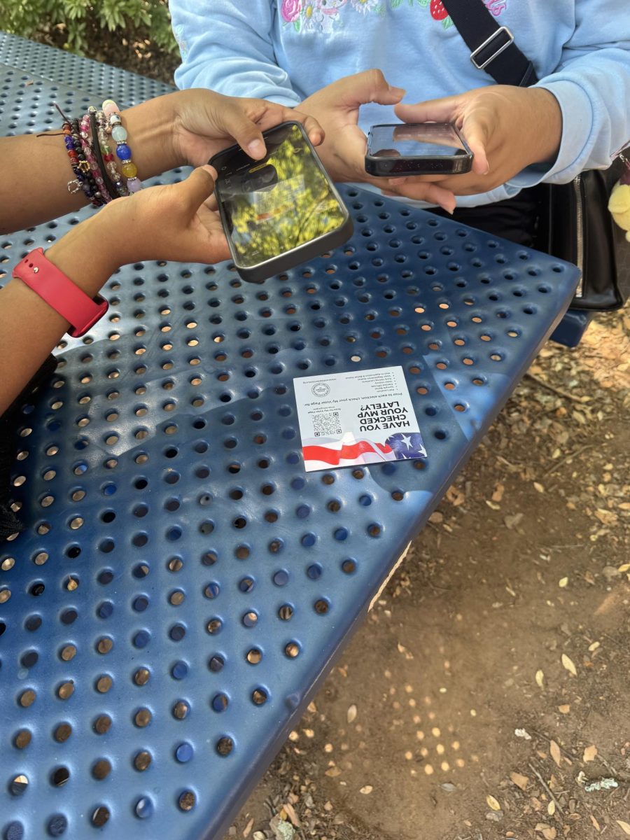 Seniors at lunch scanning the QR code for the link to register to vote.