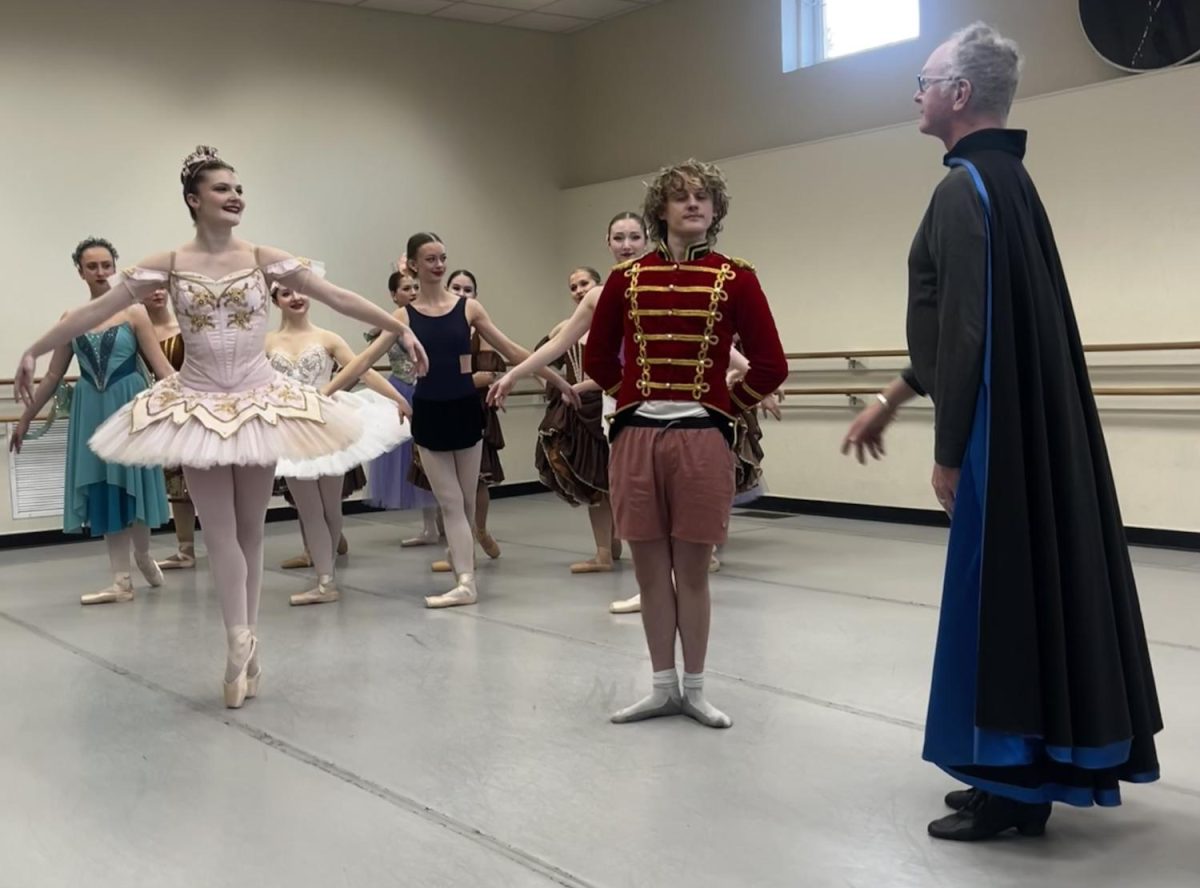 Nutcracker Bodie Quick, a junior at Pebblebrook High School, stands with Drosselmeyer as he is introduced to the Sugar Plum Fairy and the Land of Sweets characters. 
