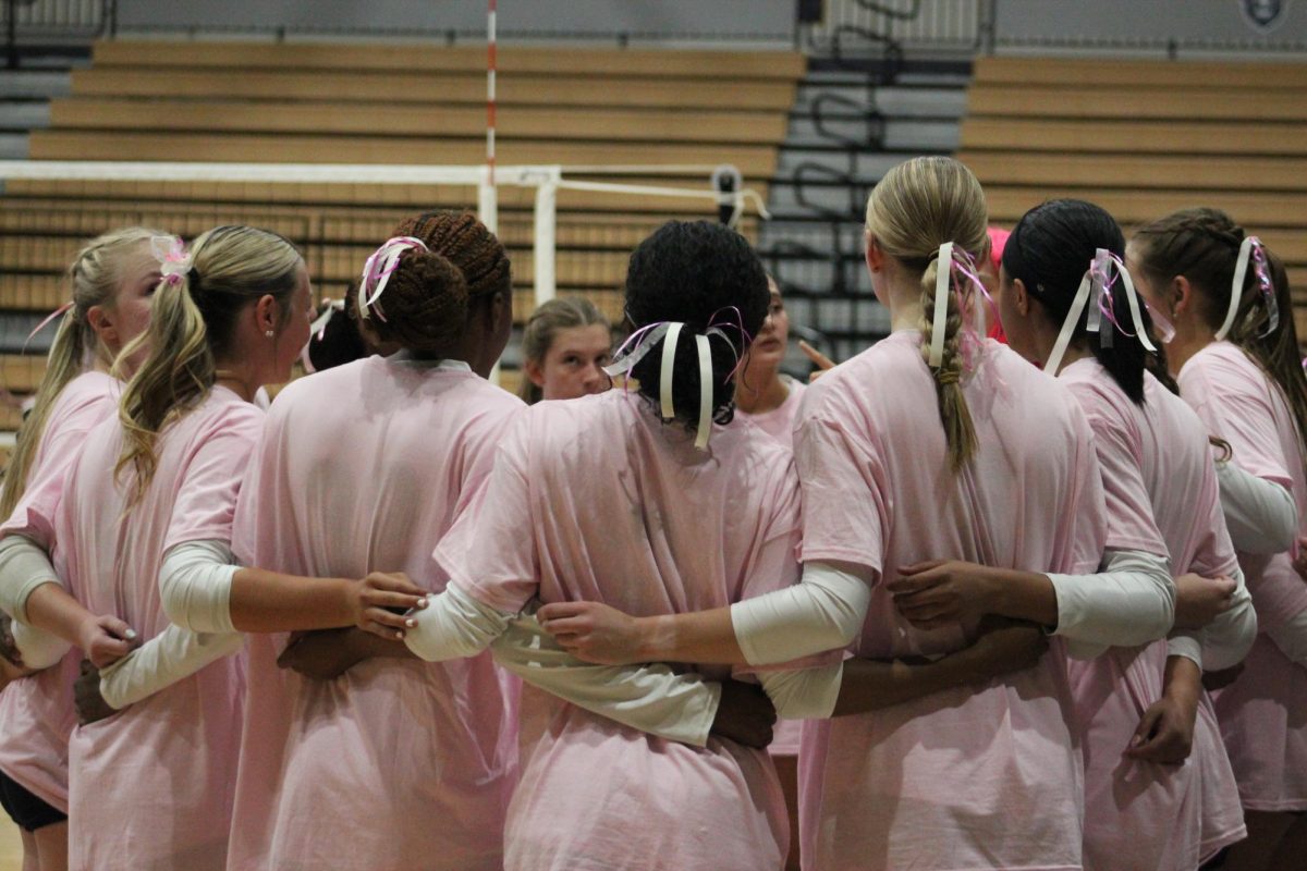 Marietta Girl's Volleyball team in a group huddle before the game.