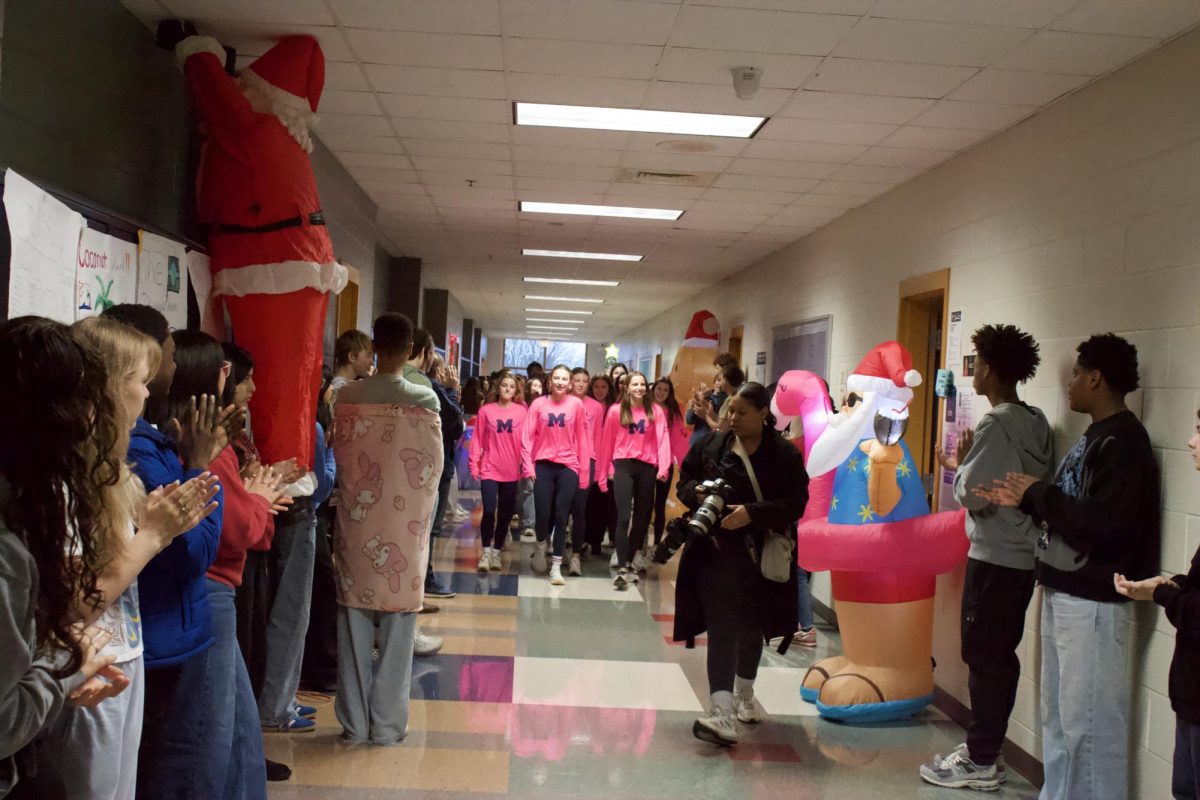XC girls walk a victory lap around MHS to begin their celebration throughout the entire school system while being documented by Tiffany Smedley, communications manager at MCS.